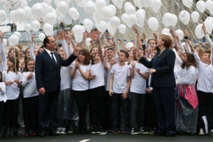 France's President Francois Hollande (L) and German Chancellor Angela Merkel (R) attend a ballon drop during a remembrance ceremony to mark the centenary of the battle of Verdun, in Verdun, on May 29, 2016. The battle of Verdun, in 1916, was one of the bloodiest episodes of World War I. The offensive which lasted 300 days claimed more than 300,000 lives. / AFP PHOTO / POOL / Thibault Camus